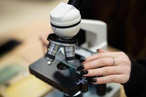 professioneel microscoop in een school- laboratorium voor de studie van cellen en bacterie foto