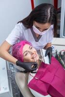 tandarts onderzoeken tanden van een jong vrouw geduldig in een tandheelkundig kliniek. tandheelkunde concept. tandarts en geduldig in de tandheelkundig kantoor. foto