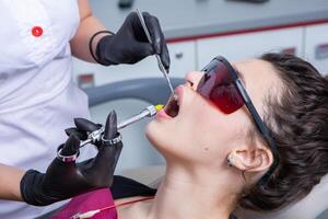 tandarts onderzoeken tanden van een jong vrouw geduldig in een tandheelkundig kliniek. tandheelkunde concept. tandarts en geduldig in de tandheelkundig kantoor. foto