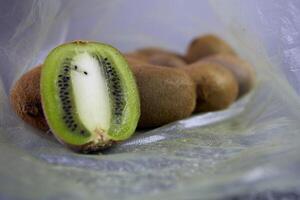 herbruikbaar wit maas boodschappen doen zak met fruit, kiwi wit-grijs marmeren achtergrond. nul verspilling concept, Nee plastic en veilig de planeet concept foto