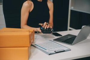 zakenvrouw begin klein bedrijf en geslaagd mkb ondernemers Aziatisch vrouw hoding dozen werken van huis leveren pakketten online. mkb levering concept en verpakking foto