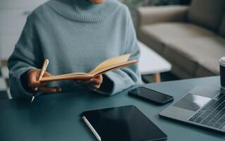 zelfverzekerd vrouw tolk vertalen document van buitenlands taal naar Engels gebruik pc app maken aantekeningen in papier kopiëren. professioneel jong vrouw editor correct fouten fouten in gedrukt artikel tekst foto