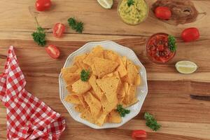 top visie Mexicaans nacho's tortilla chips met guacamole en tomaat saus dompelen foto