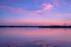 sereen wateren een zalig reflectie van een mooi pastel meer en lucht, waar kalmte voldoet aan van de natuur palet, creëren een harmonisch oase van zacht tinten en etherisch schoonheid foto