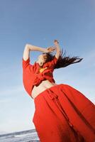 glimlachen vrouw dansen met vreugde Aan een zonnig strand foto