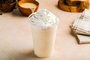 vanille milkshake met room geserveerd in glas geïsoleerd Aan tafel top visie gezond ochtend- drinken foto