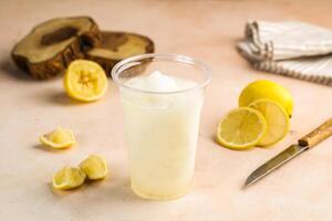 citroen sap limonade met rauw limoen plak geserveerd in glas geïsoleerd Aan tafel top visie gezond ochtend- drinken foto