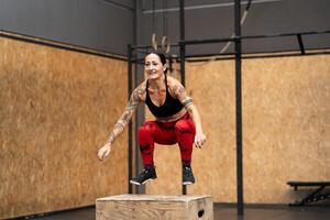 volwassen vrouw jumping in doos in een Sportschool foto