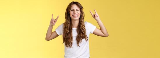 enthousiast charismatisch Lucky meisje hebben pret genieten geweldig muziek- tonen rock'n'roll gebaar grijnzend opgewonden Leuk vinden zwaar metaal dansen vrolijk positief staand vermaakt geel achtergrond foto