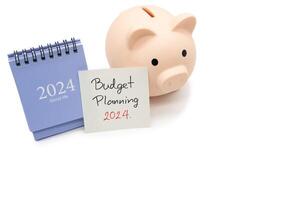begroting planning 2024 tekst bericht door hand- schrijven Aan papier Opmerking, kalender en varkentje bank. begroting planning concept. foto