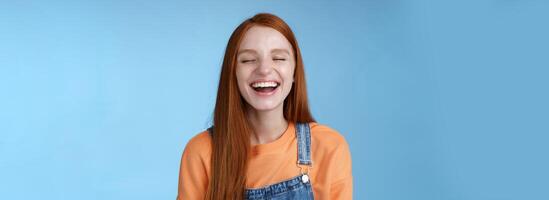 zorgeloos gelukkig positief Lucky roodharige meisje hebben pret dichtbij ogen glimlachen optimistisch lachend uit luid grinniken grappig grap luister hilarisch verhalen ontspannende hangen uit vrienden, blauw achtergrond foto