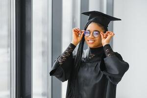 gelukkig Afrikaanse Amerikaans vrouw leerling met diploma Bij diploma uitreiking foto