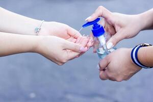 twee meisjes het wassen hun handen met alcoholische drank foto