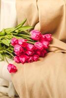 een boeket van roze bloemen genaaid Aan beige elegant linnen. foto