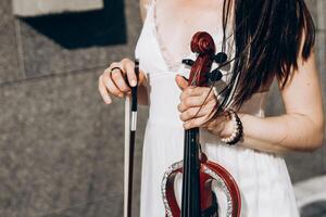 een fragment van een elektrisch viool, een viool in de handen van een van muzikant meisje foto