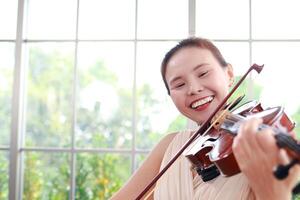 concept van aan het leren klassiek muziek. Aziatisch vrouw spelen viool klassiek musical instrumenten. leraar onderwijs studenten in kunst school. kopiëren ruimte foto