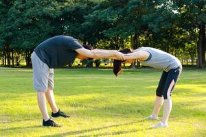 Aziatisch paar oefenen samen in de park in de ochtend- ze zijn sterk en gezond. buitenshuis oefening concept, Gezondheid zorg, opwarmen uitrekken foto