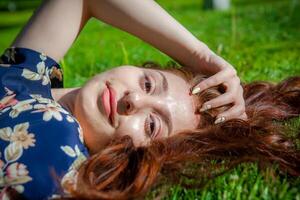 rood haren vrouw in de park, mooi vrouw in de natuur foto