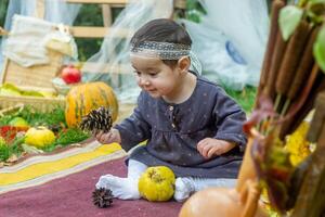 de weinig kind spelen in de park met fruit, weinig meisje in de herfst park foto