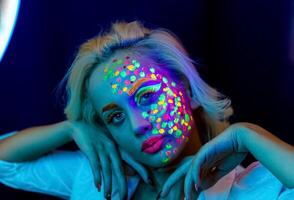 portret van een vrouw met geschilderd gezicht, vrouw met uv bedenken in studio, portret van een vrouw in carnaval masker, de vrouw is versierd in een ultraviolet poeder foto