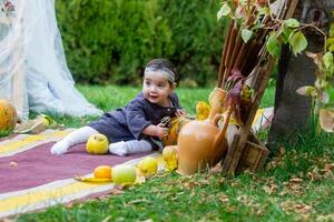 de weinig kind spelen in de park met fruit, weinig meisje in de herfst park foto