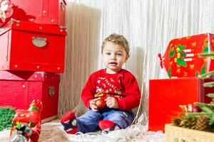 de weinig kind spelen met Kerstmis decoraties in studio, weinig kind met Kerstmis bal foto