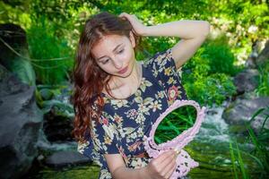 rood haren vrouw in de park, mooi vrouw in de natuur foto