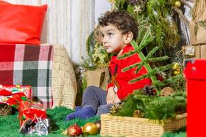 de weinig kind spelen met Kerstmis decoraties in studio, weinig kind met Kerstmis bal foto