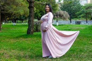 de zwanger vrouw in de park, mooi vrouw in de park, zwanger vrouw in voorjaar foto