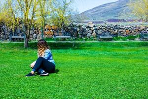 vrouw in de bergen, mooi blond meisje Aan de heuvel, jong vrouw mediteren, jong vrouw zittend Aan een gras foto