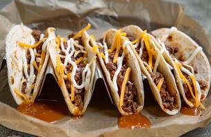 ai gegenereerd een heerlijk vlees taco's bekroond met kaas en saus, kleurrijk Mexicaans voedsel foto