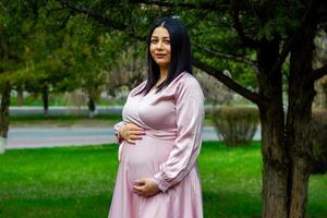 de zwanger vrouw in de park, mooi vrouw in de park, zwanger vrouw in voorjaar foto