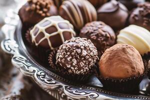 ai gegenereerd assortiment van chocola snoepjes Aan zilver bord. foto