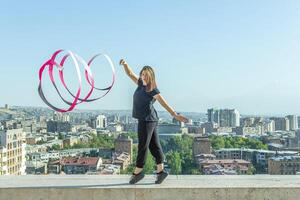 jong meisje aan het doen oefening in de stad, vrouw aan het doen yoga oefening, persoon aan het doen uitrekken, vrouw ontspannende in de stad, mooi meisje aan het doen geschiktheid oefening foto