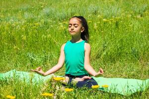 weinig meisje in de veld, weinig meisje aan het doen yoga opdrachten in de park foto