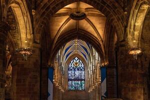 gotisch kathedraal interieur met gewelfd plafonds en gebrandschilderd glas venster. foto