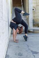 jong meisje aan het doen oefening in de stad, vrouw aan het doen yoga oefening, persoon aan het doen uitrekken, vrouw ontspannende in de stad, mooi meisje aan het doen geschiktheid oefening foto