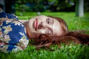 rood haren vrouw in de park, mooi vrouw in de natuur foto