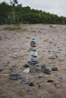piramide van steentjes Aan de strand, concept van balans foto