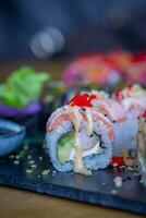 sushi broodjes Aan een zwart bord Aan een houten tafel in een restaurant foto