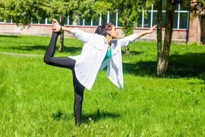 jong vrouw aan het doen yoga opdrachten in de park foto