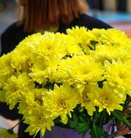 vrouw Holding boeket van geel bloemen foto