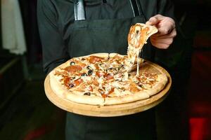 chef in schort Holding pizza foto
