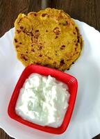 Indisch ontbijt gerecht.gevuld aardappel paratha of channa dal paratha geserveerd met wrongel. selectief focus foto