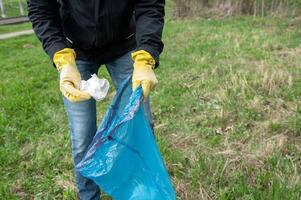 persoon plukken afval met geel handschoenen foto