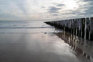 noorden zee kust, somber zonsondergang achter regen wolken foto