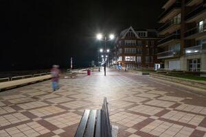 nacht schot van een promenade met bank en lantaarn foto