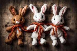 ai gegenereerd drie gevuld konijntjes met oranje lint gebonden in de omgeving van hun nekken foto