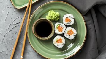 ai gegenereerd een groen bord versierd met futomaki sushi, vergezeld door een klein kom van shoyu. twee eetstokjes rust uit Daarnaast, uitnodigend een culinaire beleven. foto