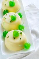 vanille puddingen versierd met cocktail kersen foto